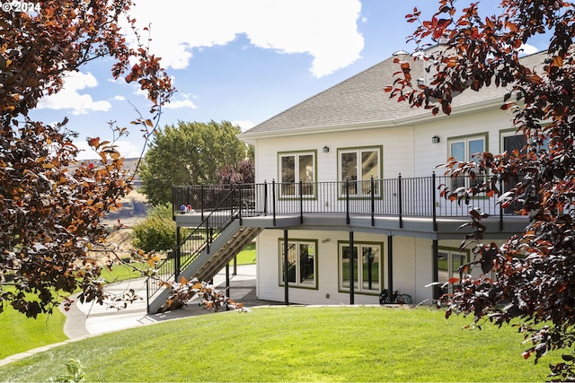 rear view of property featuring a yard, a wooden deck, and a patio