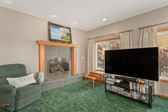 living room with a tiled fireplace, plenty of natural light, and carpet