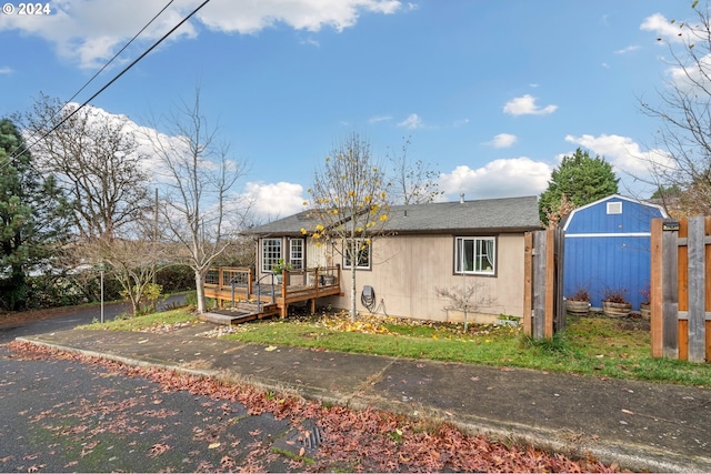 view of front of home featuring a wooden deck and a shed