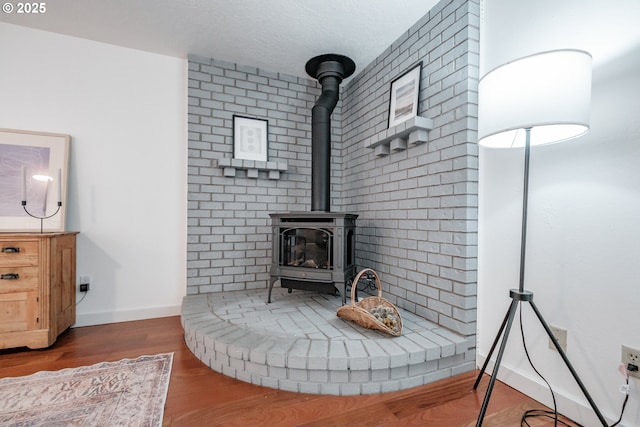 details featuring wood-type flooring, a textured ceiling, and a wood stove