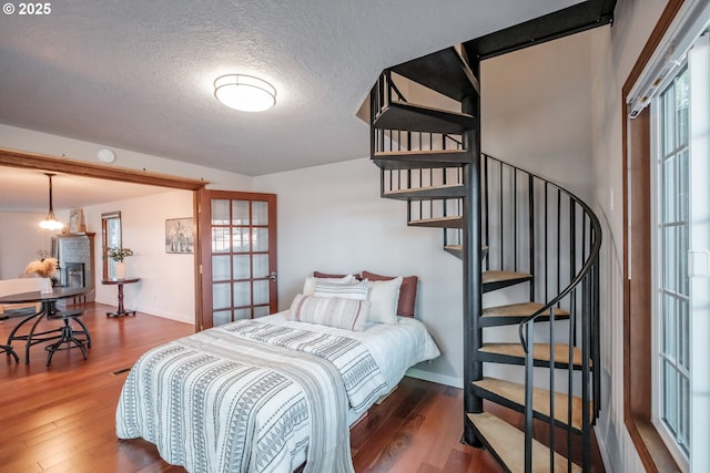 bedroom with dark hardwood / wood-style floors and a textured ceiling