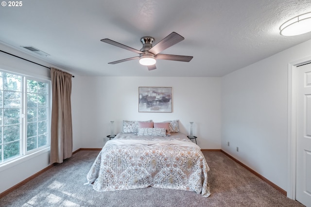 carpeted bedroom with multiple windows and ceiling fan