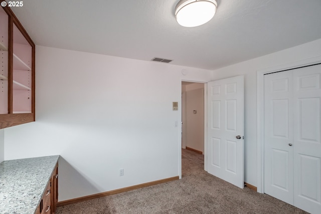 unfurnished bedroom featuring a closet and light carpet