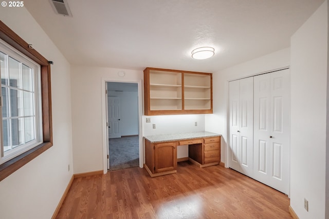 interior space with built in desk and light wood-type flooring