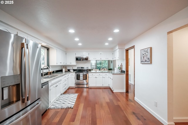 kitchen featuring white cabinetry, appliances with stainless steel finishes, sink, and a wealth of natural light