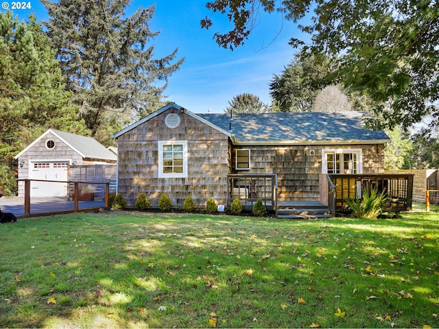 ranch-style house featuring a garage, a front lawn, an outdoor structure, and a wooden deck