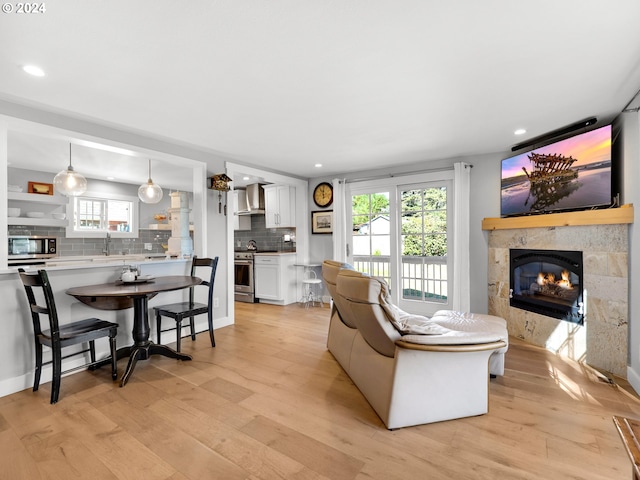 living room featuring sink, a fireplace, and light hardwood / wood-style flooring