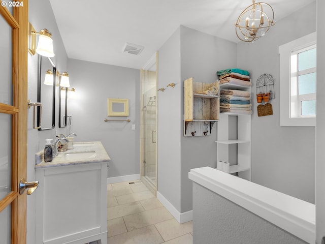 bathroom featuring vanity, an inviting chandelier, tile patterned floors, and a shower with shower door