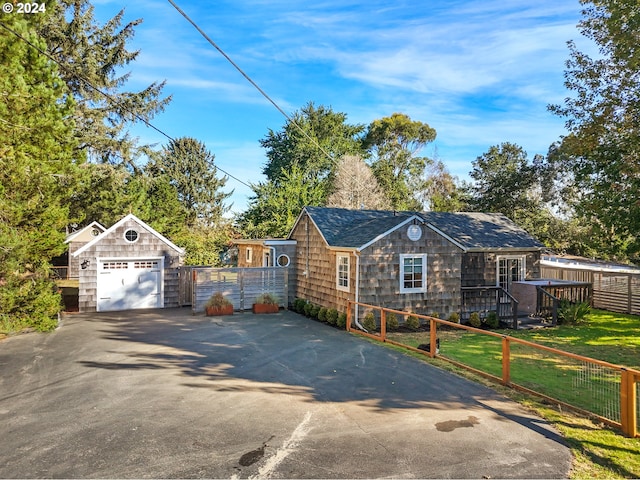 view of front of house featuring a garage, an outdoor structure, and a front yard