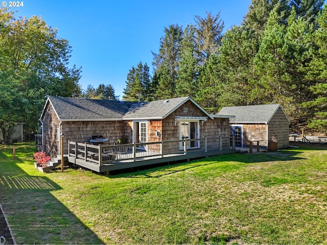 rear view of house featuring a yard and a deck