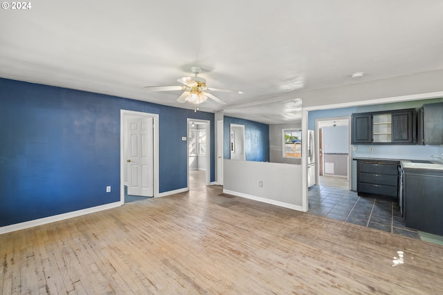 unfurnished living room featuring ceiling fan, dark hardwood / wood-style flooring, and sink