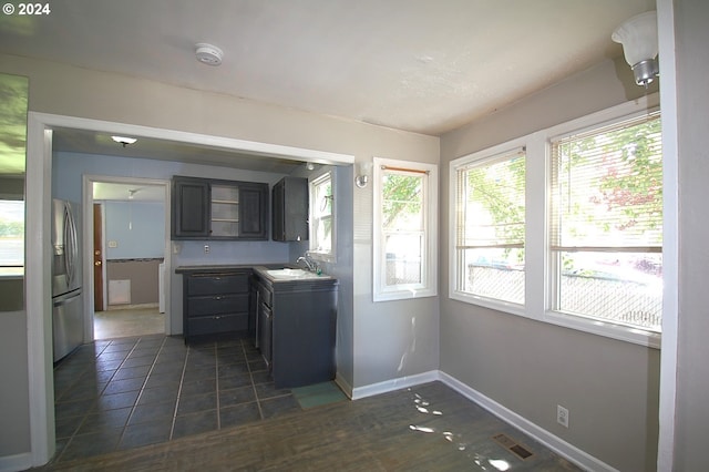 kitchen featuring stainless steel refrigerator with ice dispenser, dark tile patterned floors, and sink