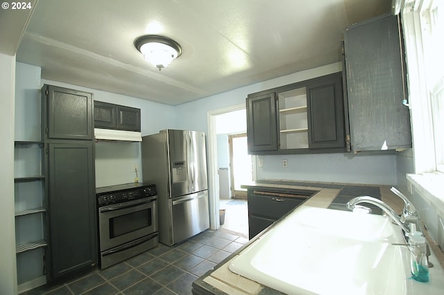 236 NE 156th Ave Unit A & B, Portland, OR 97230 - kitchen with appliances with stainless steel finishes, open shelves, under cabinet range hood, a sink, and dark tile patterned flooring