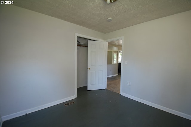 unfurnished bedroom with a textured ceiling and a closet