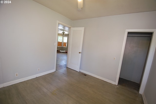 unfurnished bedroom featuring dark hardwood / wood-style flooring and a closet