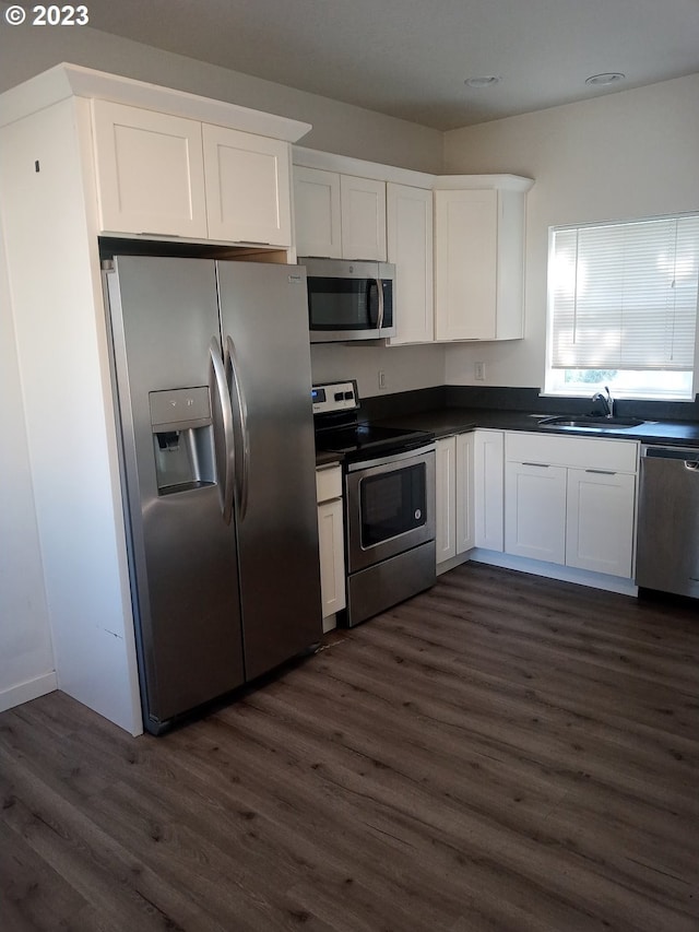 236 NE 156th Ave Unit A & B, Portland, OR 97230 - kitchen with appliances with stainless steel finishes, a sink, dark wood-style floors, dark countertops, and white cabinetry