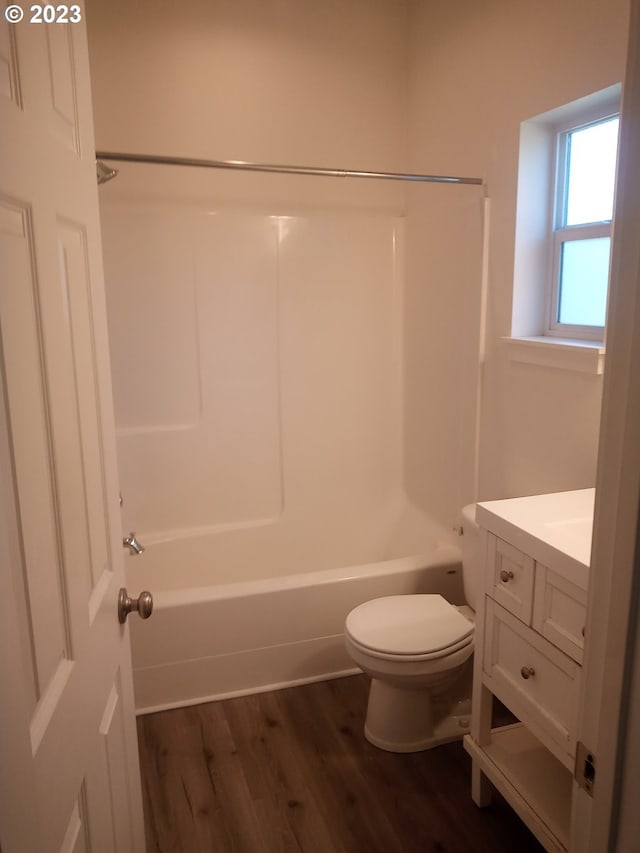 full bathroom featuring hardwood / wood-style floors, vanity, toilet, and shower / washtub combination