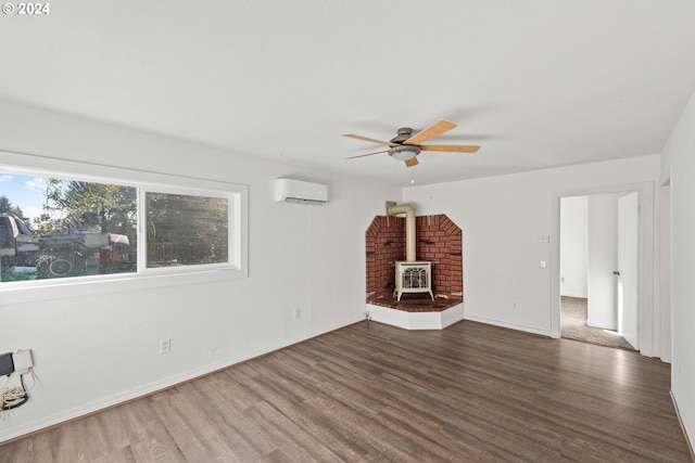 unfurnished living room with ceiling fan, dark hardwood / wood-style flooring, a wood stove, and a wall mounted AC