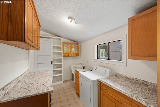 laundry room featuring washer / clothes dryer, cabinets, and a textured ceiling