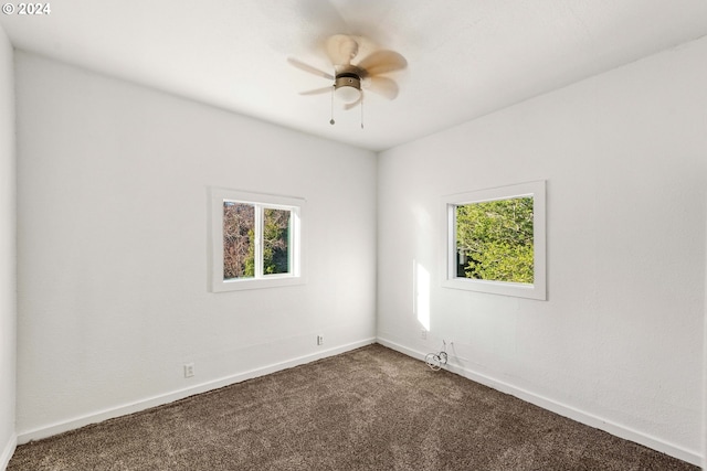 carpeted spare room featuring ceiling fan and a healthy amount of sunlight