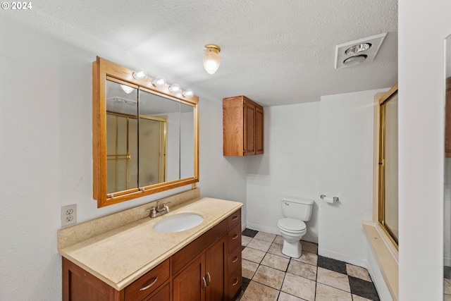 bathroom featuring tile patterned flooring, vanity, toilet, and a textured ceiling