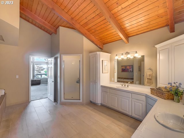 bathroom with high vaulted ceiling, an enclosed shower, beam ceiling, and wood ceiling