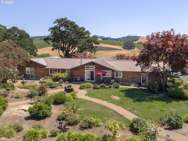 view of front of house featuring a front yard, a rural view, and a patio area