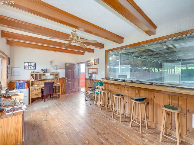 bar featuring ceiling fan, light hardwood / wood-style floors, and beam ceiling