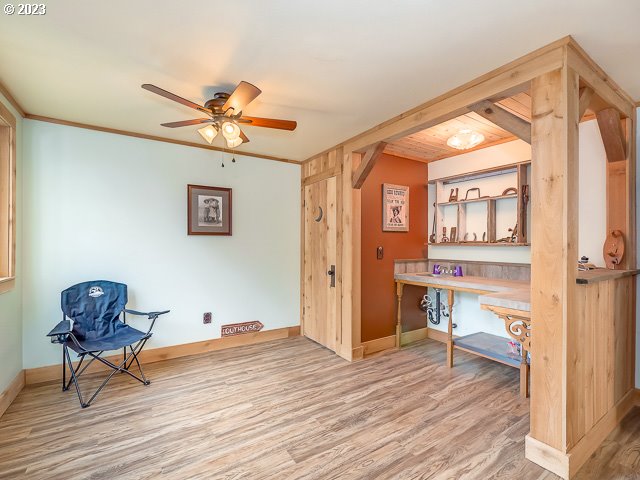 living area with ceiling fan, light wood-type flooring, and ornamental molding