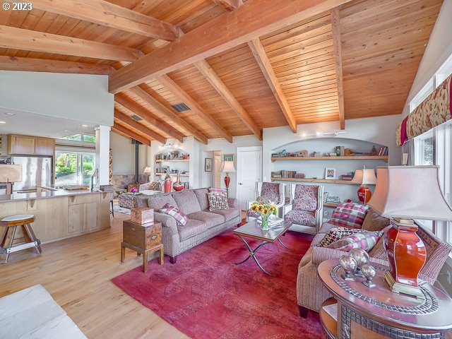 living room with light hardwood / wood-style flooring, wooden ceiling, and lofted ceiling with beams