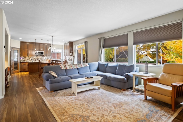 living room with a textured ceiling and dark hardwood / wood-style flooring