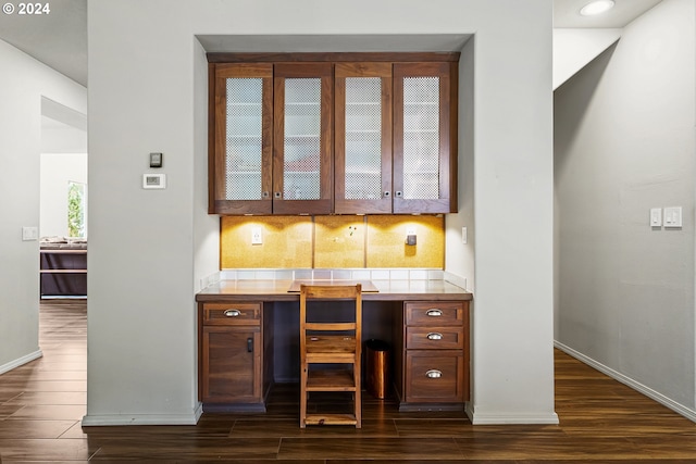 bar featuring tile counters, decorative backsplash, and dark hardwood / wood-style floors