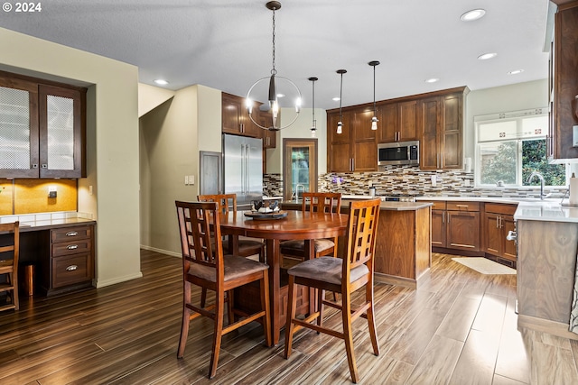 dining area with a notable chandelier, dark hardwood / wood-style flooring, and sink