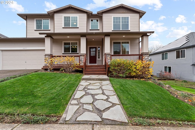 view of front of house with a front yard, a porch, and a garage