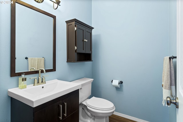 bathroom with hardwood / wood-style flooring, vanity, and toilet