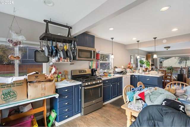 7010 SE Lamphier St, Milwaukie, OR 97222 - kitchen with appliances with stainless steel finishes, blue cabinetry, a peninsula, light countertops, and healthy amount of natural light