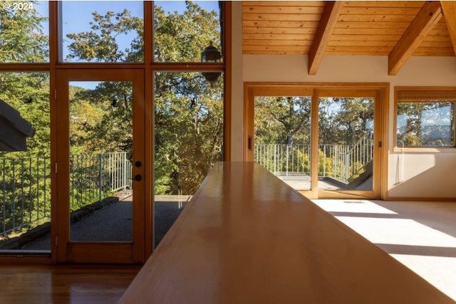 unfurnished sunroom with beamed ceiling and wood ceiling