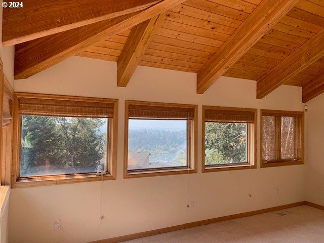 empty room featuring carpet, wood ceiling, and vaulted ceiling with beams