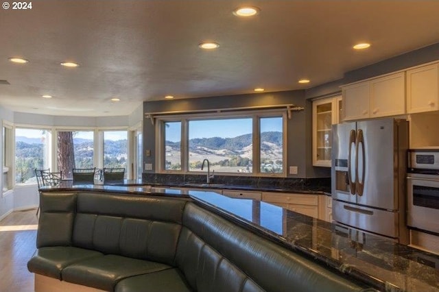 kitchen with appliances with stainless steel finishes, plenty of natural light, a mountain view, and sink