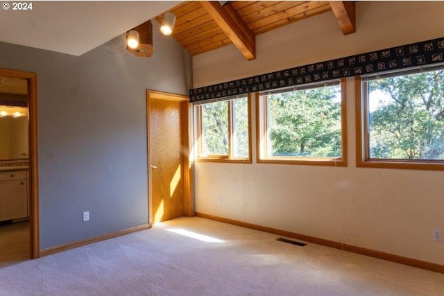 carpeted empty room with plenty of natural light, wood ceiling, and lofted ceiling with beams