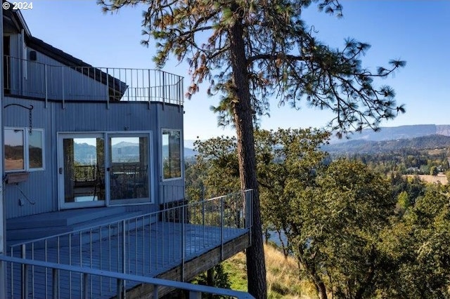 view of property exterior with a deck with mountain view