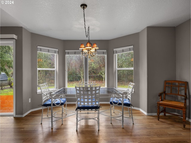 living area with a chandelier, a textured ceiling, and wood-type flooring