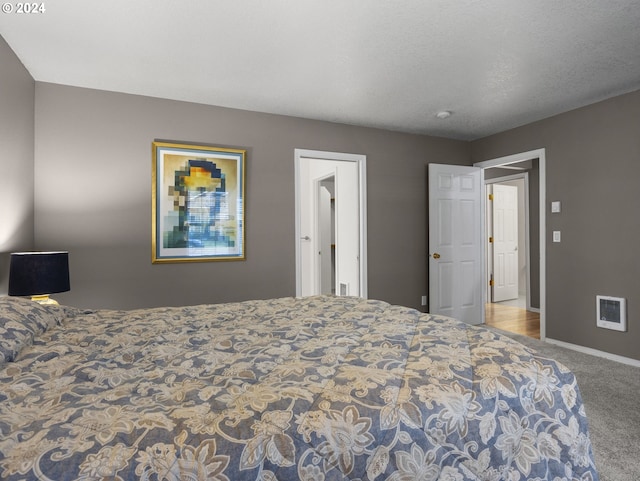 bedroom with a textured ceiling and light colored carpet