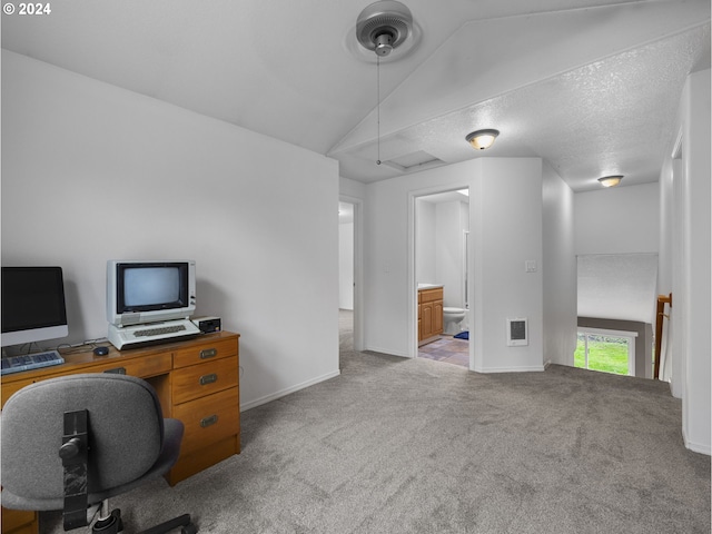 carpeted home office featuring lofted ceiling and a textured ceiling