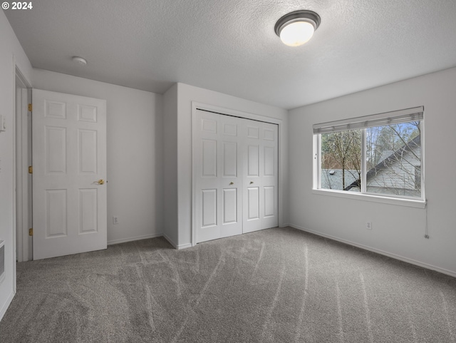 unfurnished bedroom featuring a closet, carpet floors, and a textured ceiling