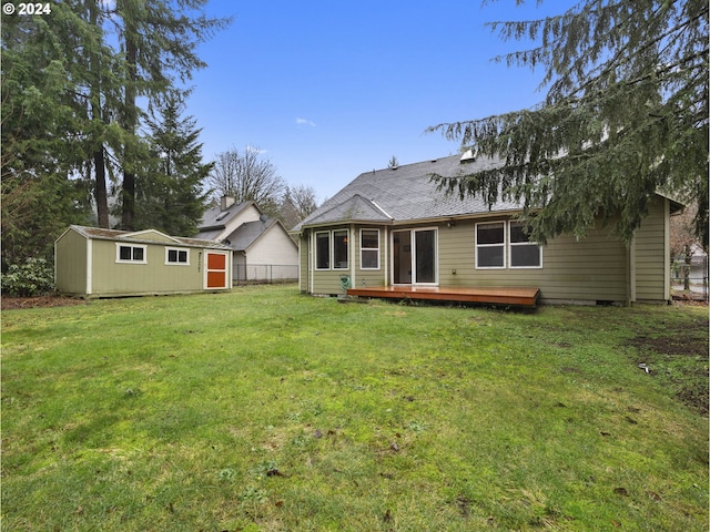 back of house featuring an outdoor structure, a yard, and a wooden deck