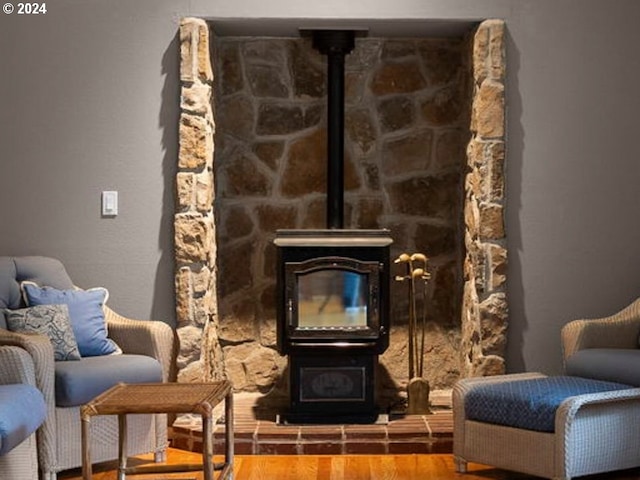 living area with a wood stove and wood-type flooring