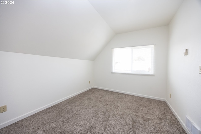 bathroom with lofted ceiling, toilet, hardwood / wood-style floors, and a shower