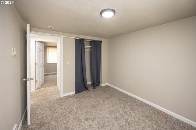 empty room with a wealth of natural light, a wall unit AC, wood-type flooring, and a chandelier