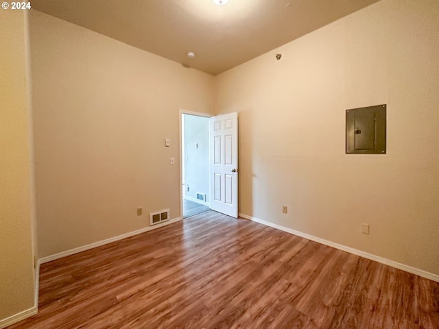 unfurnished room with electric panel and dark hardwood / wood-style floors